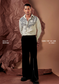 Man wearing HORD Bespoke ivory shirt with black baroque scroll embroidery across the shoulders, full-length studio shot