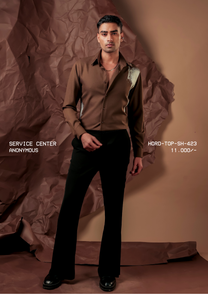 Man wearing HORD Anonymous brown shirt with pale sage paint-splash panels, full-length studio shot