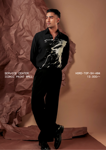 Man wearing HORD Iconic Paint Ball black shirt with gold paint splatter, full-length studio shot