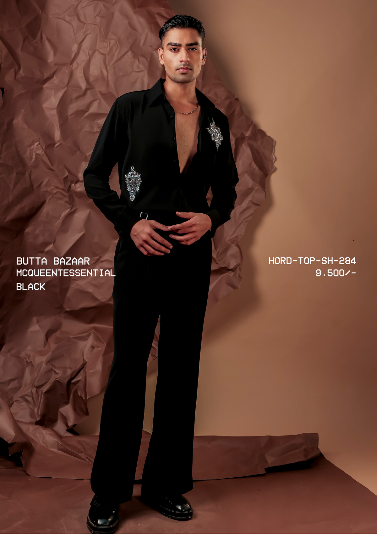Man wearing HORD McQueentessential black shirt with silver beaded butta motifs, full-length studio shot