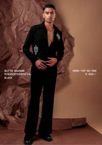 Man wearing HORD McQueentessential black shirt with silver beaded butta motifs, full-length studio shot