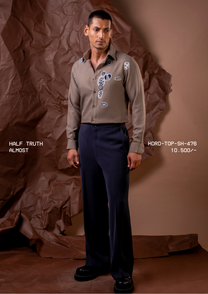 Man wearing HORD Almost mushroom grey shirt with black and white embroidered paisley motifs, full-length studio shot