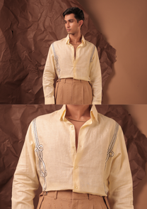 Close-up of HORD Slow Clap shirt showing black and white cord knots running down pale lemon front