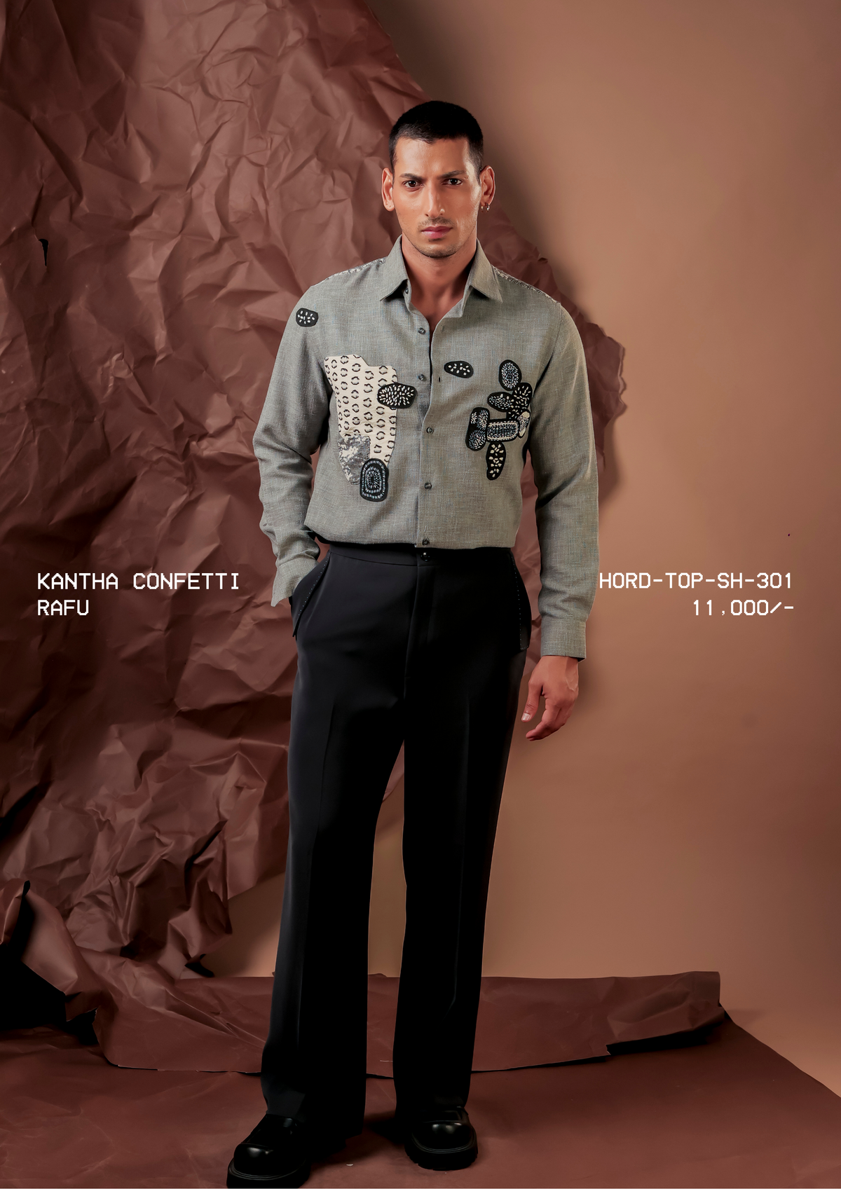 Man wearing HORD Rafu grey shirt with black and ivory kantha embroidered patches, full-length studio shot