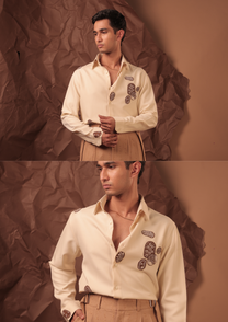 Close-up of HORD Anyways shirt showing brown embroidered motifs on cream