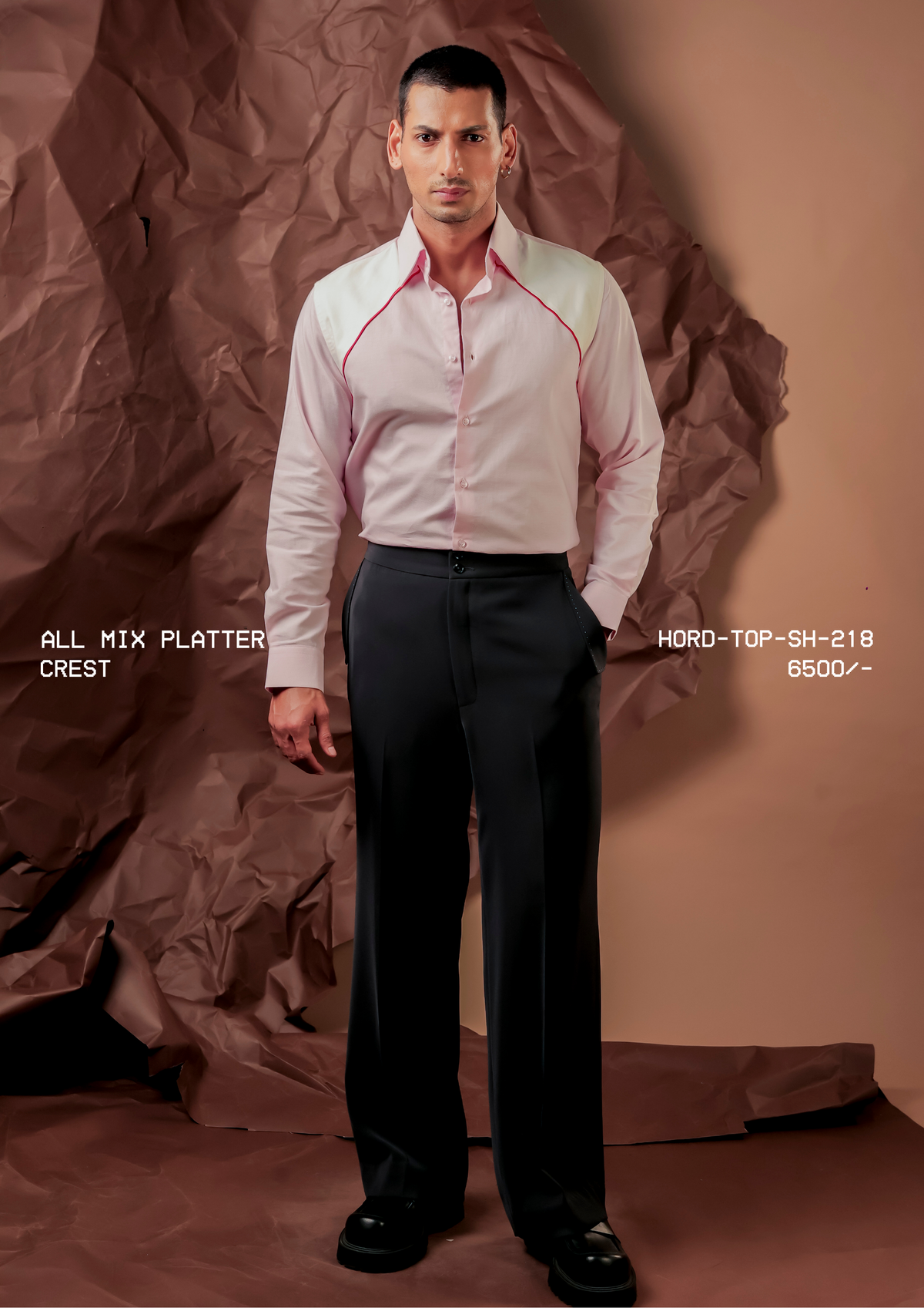 Man wearing HORD Crest pale pink shirt with ivory raglan shoulder panels and red piping, full-length studio shot