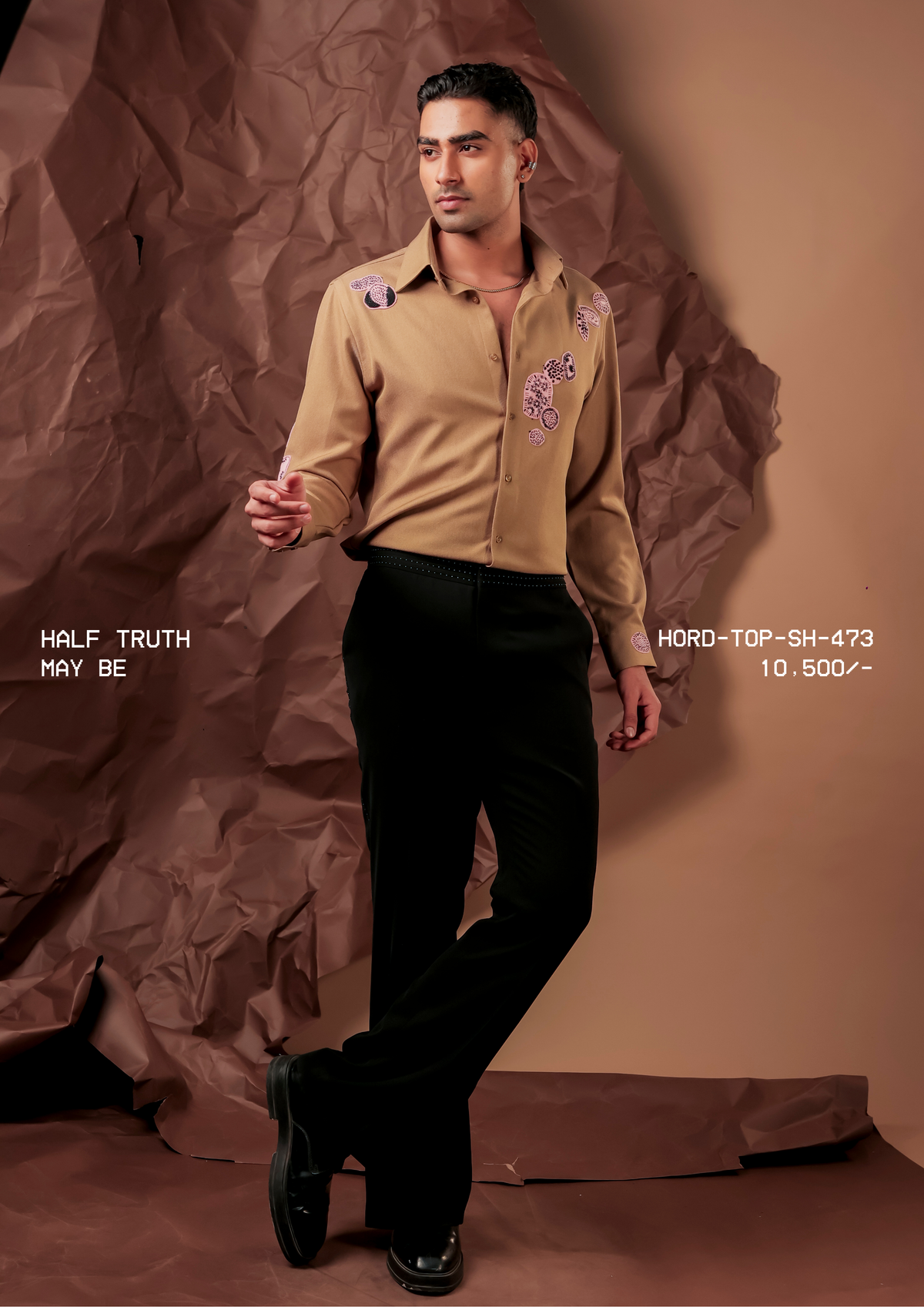 Man wearing HORD May Be camel shirt with lilac embroidered paisley motifs, full-length studio shot