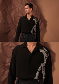 Close-up of HORD Decay shirt showing eroded silver-grey texture climbing over black shoulder