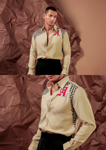 Close-up of HORD Hypotenuse shirt showing geometric print panels and red gothic letter embroidery