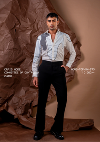 Man wearing HORD Committee of Controlled Chaos ivory shirt with black grid shoulder panel and contour piping, full-length studio shot