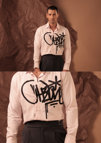 Close-up of HORD Imposter shirt showing black graffiti tag with drips on blush pink