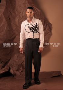 Man wearing HORD Imposter blush pink shirt with oversized black graffiti tag print, full-length studio shot