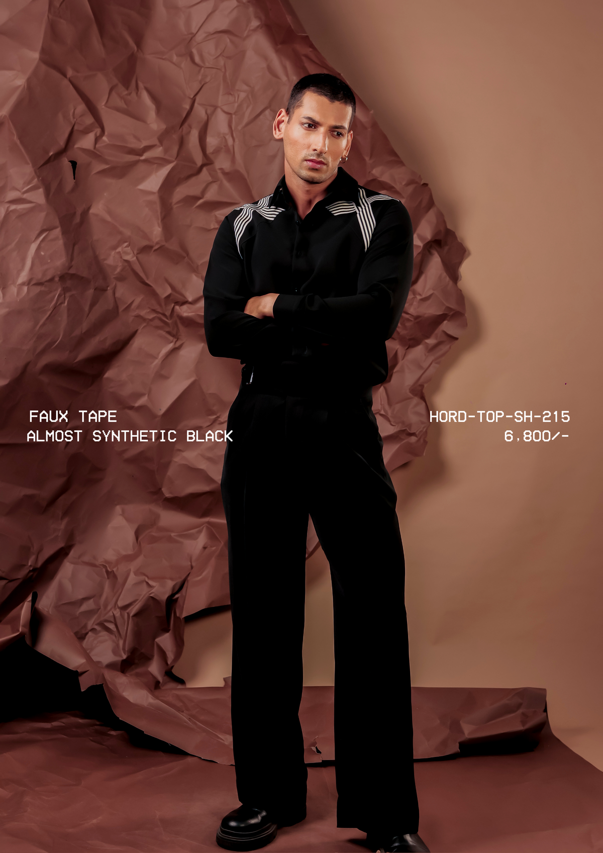 Man wearing HORD Almost Synthetic Black shirt with crossed ivory tape bands over the shoulders, full-length studio shot
