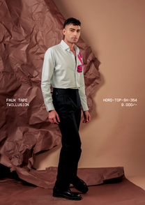 Man wearing HORD Twillusion pale grey shirt with twisted red and navy striped tape motif, full-length studio shot