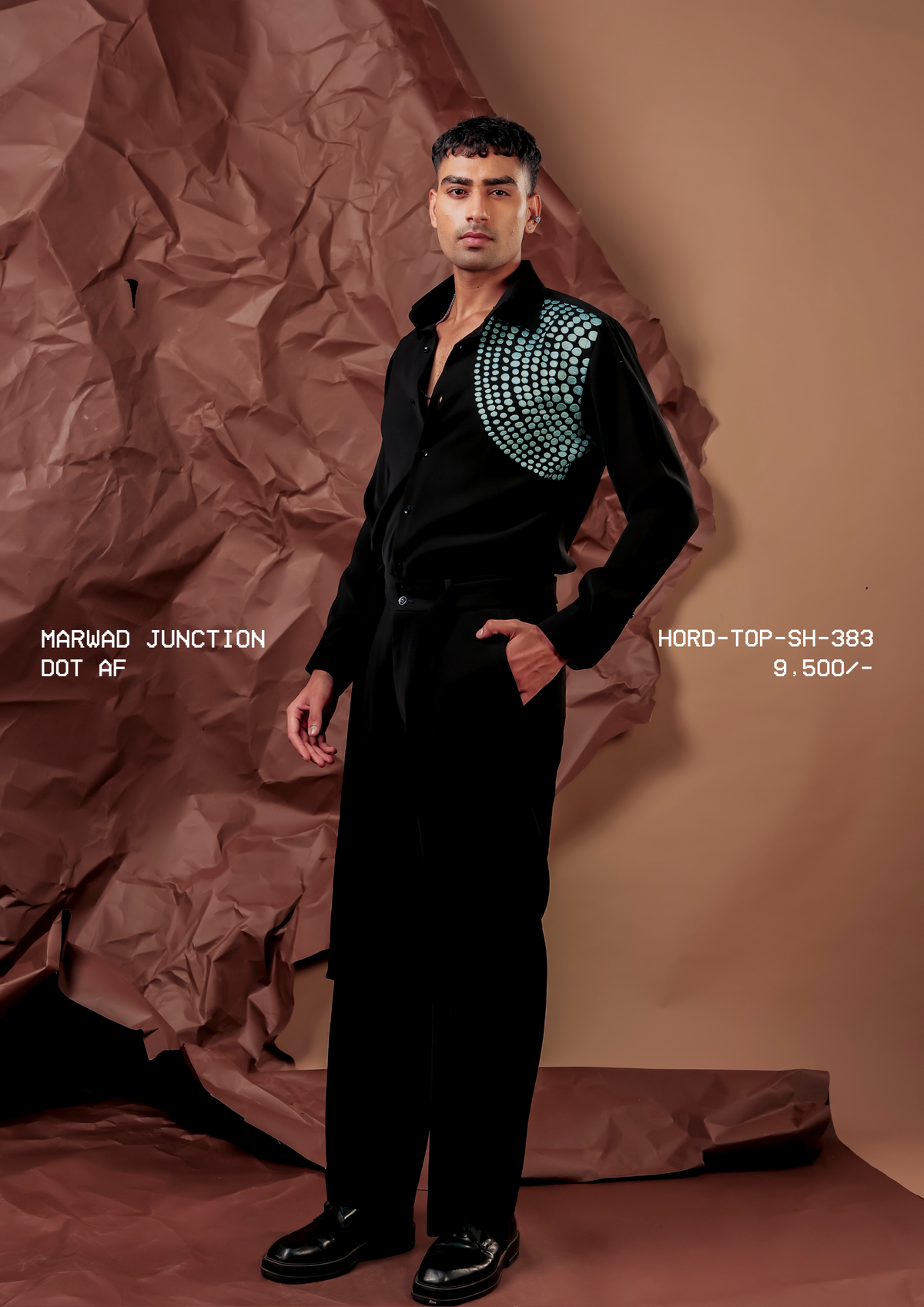 Man wearing HORD Dot AF black shirt with aqua dot embellishment across the shoulder, full-length studio shot
