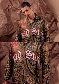 Close-up of HORD Dead Stock shirt showing gold, green and fuchsia paisley with white blackletter text