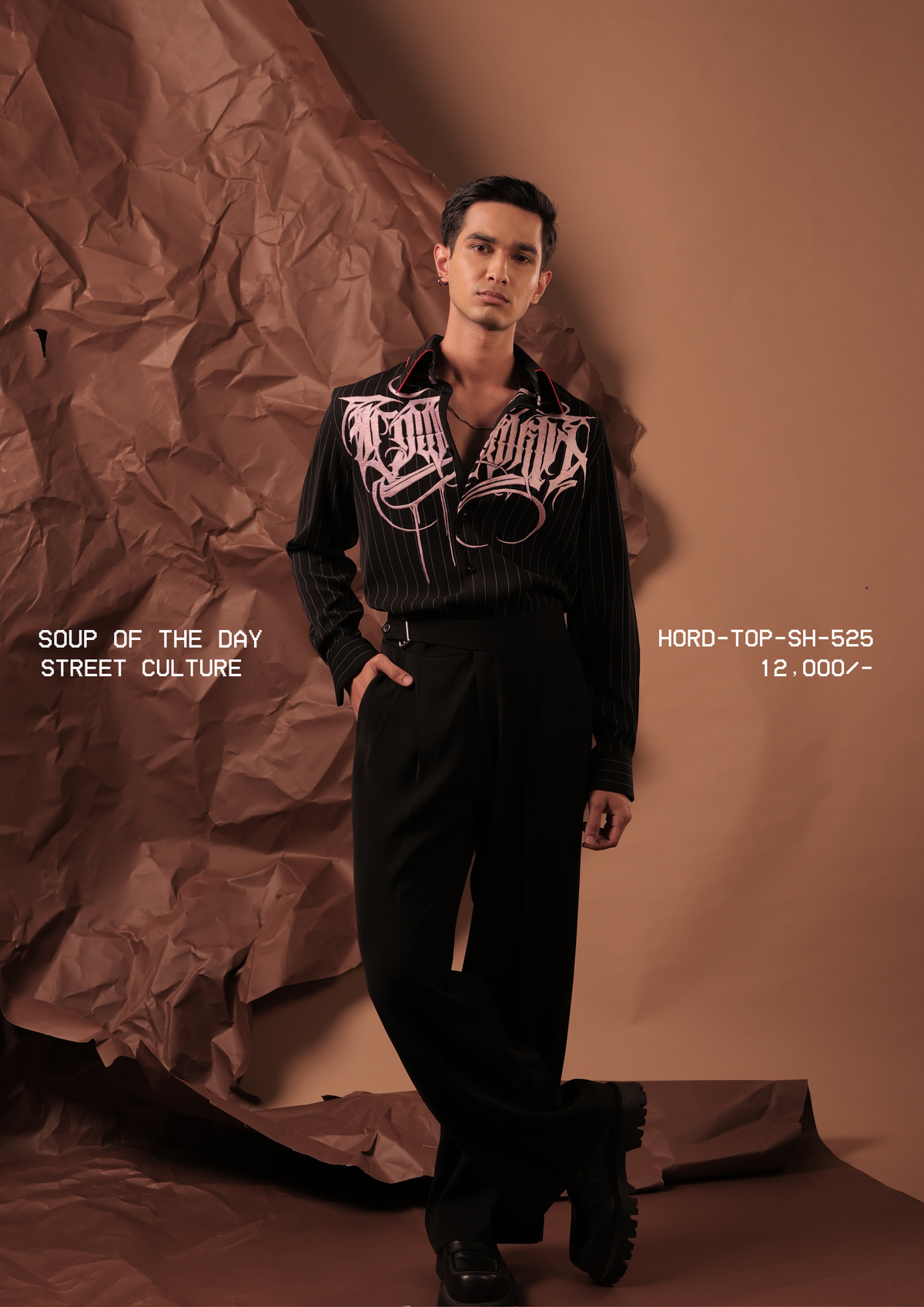 Man wearing HORD Street Culture black pinstripe shirt with pink gothic calligraphy embroidery, full-length studio shot