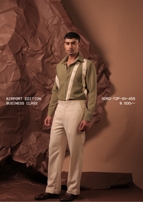 Man wearing HORD Business Class olive shirt with vertical cream straps and triangle hardware, styled with cream trousers