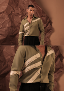 Close-up of HORD Terminal Boys shirt showing cream diagonal straps with silver triangle rings on sage