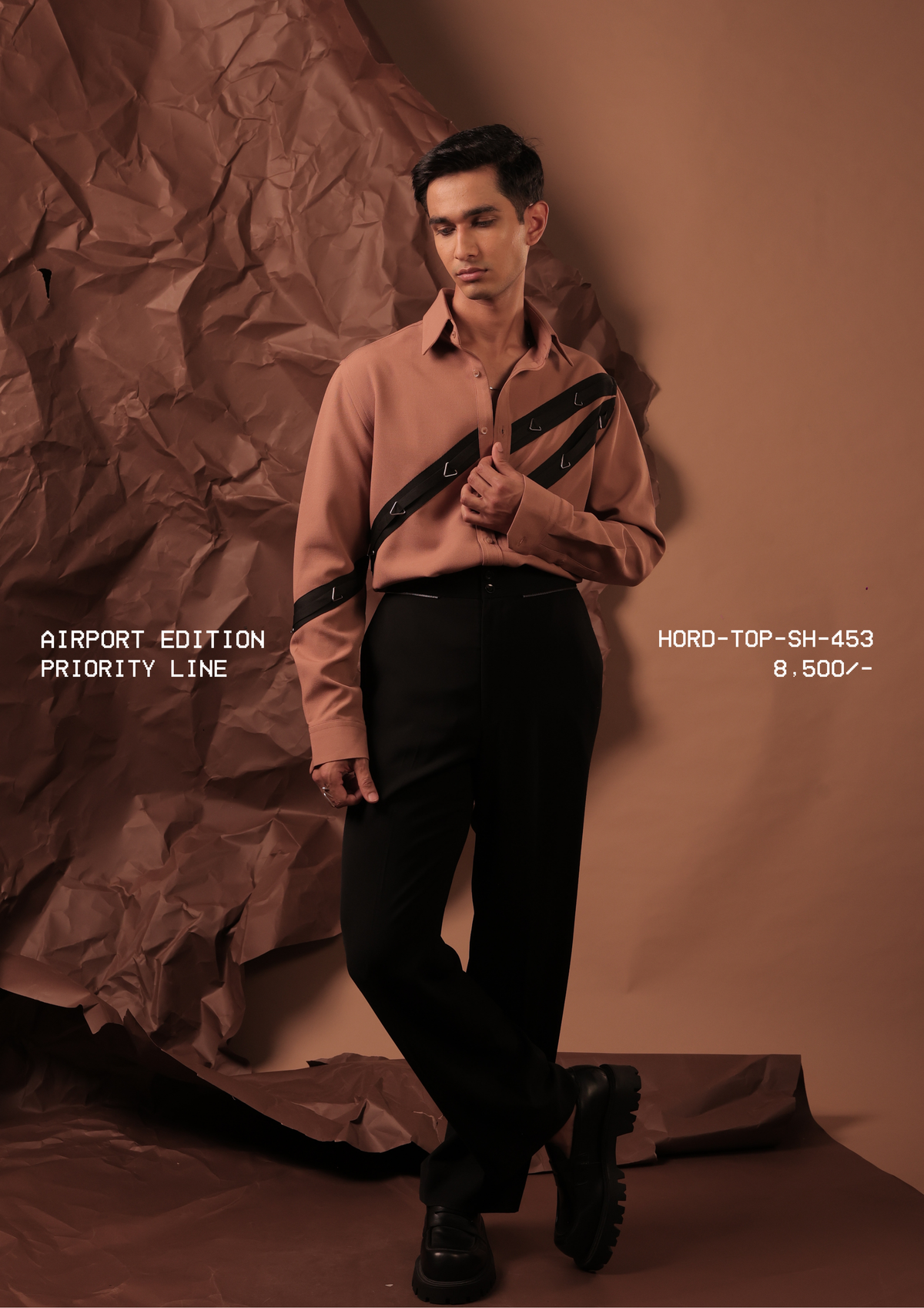 Man wearing HORD Priority Line terracotta shirt with black diagonal straps and triangle hardware, full-length studio shot