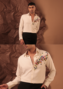 Close-up of HORD Loading shirt showing cascade of multicolour pixel embroidery on ivory