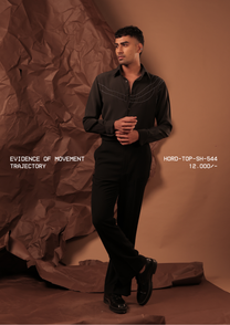 Man wearing HORD Trajectory black shirt with ivory topstitch arcs across the chest, full-length studio shot