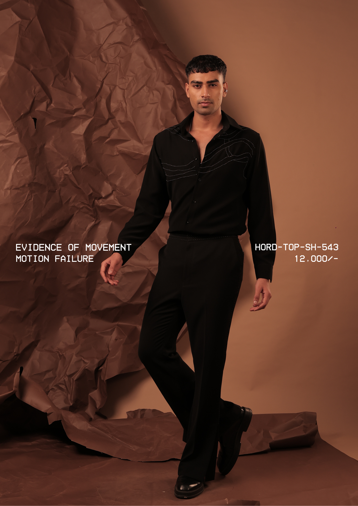 Man wearing HORD Motion Failure black shirt with wavering ivory topstitch lines, full-length studio shot