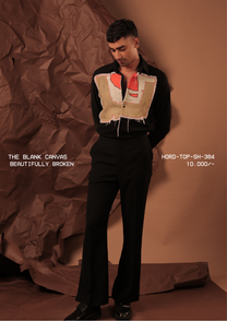 Man wearing HORD Beautifully Broken black shirt with raw-edged hand-painted khaki bib panel, full-length studio shot