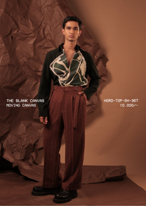 Man wearing HORD Moving Canvas forest green shirt with raw-edged diamond art panel, styled with rust trousers