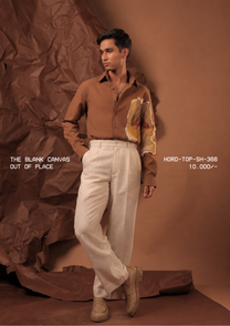 Man wearing HORD Out Of Place caramel shirt with raw-edged mustard art panel, styled with cream trousers