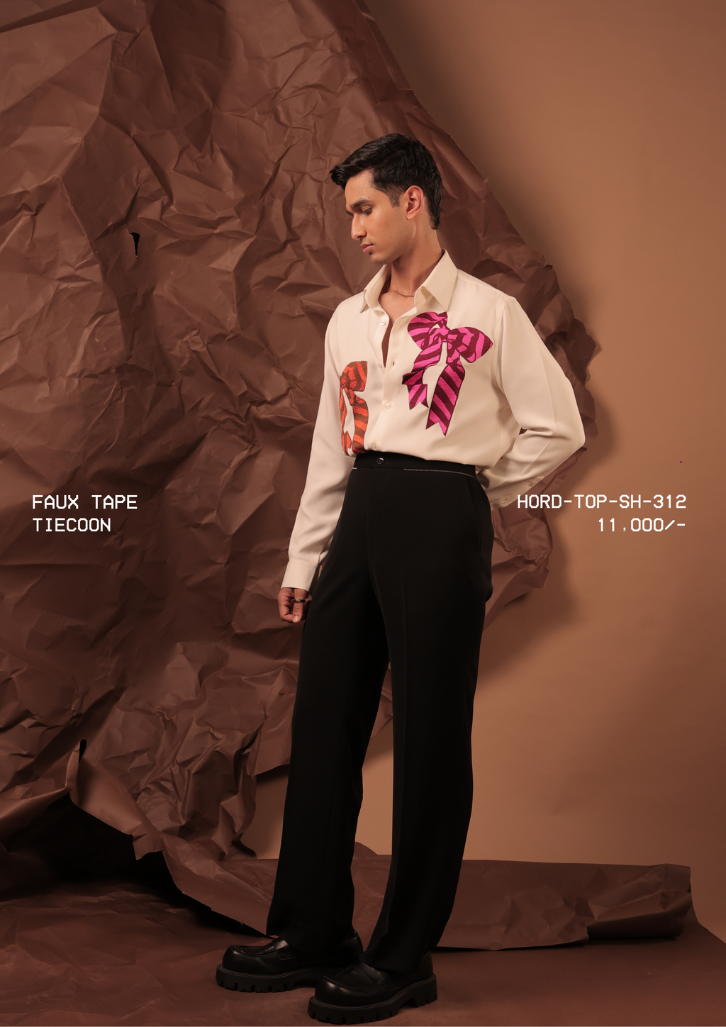 Man wearing HORD Tiecoon ivory shirt with oversized rust and magenta striped bow motifs, full-length studio shot