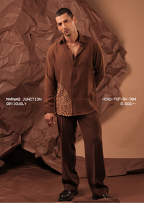Man wearing HORD Obviously cocoa brown shirt with gold dot embellishment at the hem, styled as a brown co-ord